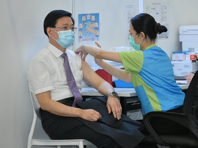 保安局局長李家超（左）今日（二月二十二日）到設於香港中央圖書館展覽館的社區疫苗接種中心接種新冠疫苗。