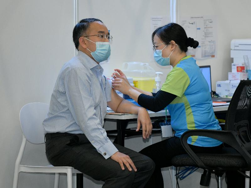 財經事務及庫務局局長許正宇（左）今日（二月二十二日）到設於香港中央圖書館展覽館的社區疫苗接種中心接種新冠疫苗。