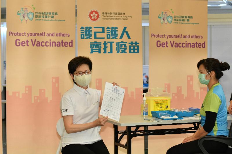 The Chief Executive, Mrs Carrie Lam, with a number of Department Secretaries and Bureaux Directors, received COVID-19 vaccinations today (February 22) at the Community Vaccination Centre at the Hong Kong Central Library Exhibition Gallery. Photo shows Mrs Lam (left) with the vaccination record. 