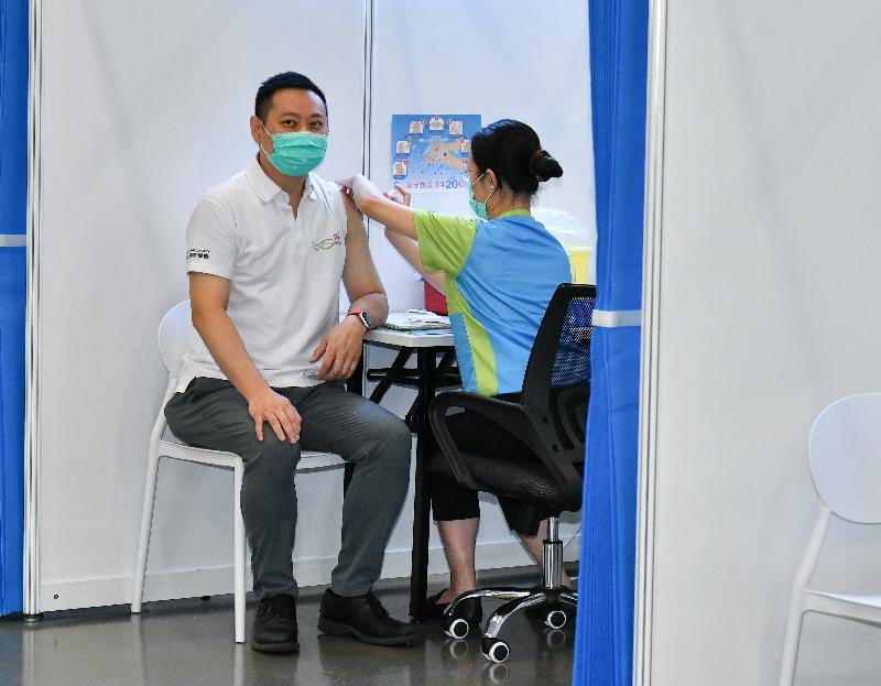 The Secretary for Home Affairs, Mr Caspar Tsui (left), receives COVID-19 vaccination today (February 22) at the Community Vaccination Centre at the Hong Kong Central Library Exhibition Gallery.