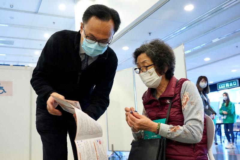 約二百名優先接種組別人士今日（二月二十三日）率先在設於香港中央圖書館展覽館的社區疫苗接種中心接種新冠疫苗，公務員事務局局長聶德權到場視察，並與一名長者交談。