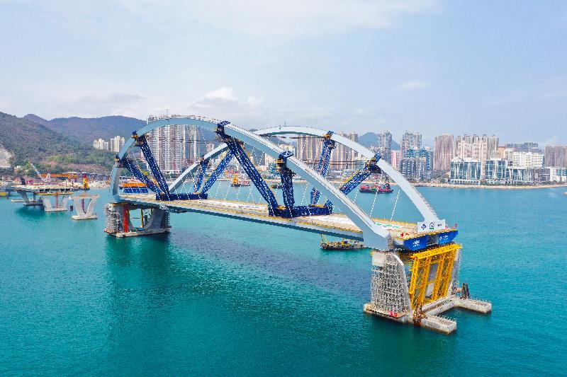 Erection of the prefabricated double-arch steel bridge for the Cross Bay Link, Tseung Kwan O, was completed today (February 26), marking a key milestone for the Cross Bay Link project.

