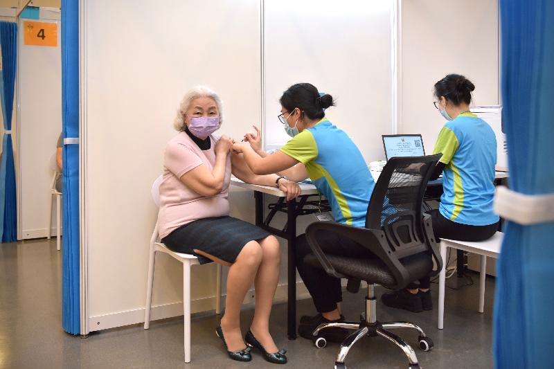 The COVID-19 Vaccination Programme was officially launched today (February 26). Photo shows the former Secretary for Justice, Miss Elsie Leung (left), receiving her COVID-19 vaccination at the Community Vaccination Centre at the Hong Kong Central Library Exhibition Gallery.