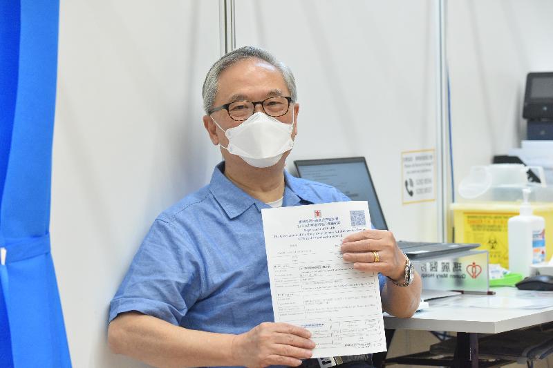 Around 100 people in the vaccination priority groups today (March 8) received the Comirnaty vaccine at the Community Vaccination Centre at the Sun Yat Sen Memorial Park Sports Centre. Photo shows the former Chief Executive, Mr Donald Tsang, with his vaccination record after getting his jab.