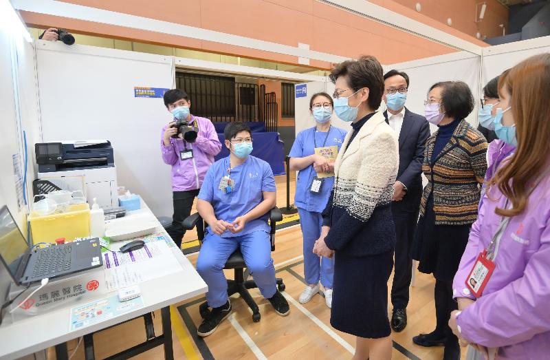 The Chief Executive, Mrs Carrie Lam, today (March 10) visited the Community Vaccination Centre at Sun Yat Sen Memorial Park Sports Centre. Photo shows Mrs Lam (fourth right) being briefed by the healthcare workers on the operation of the centre. Looking on are the Secretary for the Civil Service, Mr Patrick Nip (fifth left) and the Secretary for Food and Health, Professor Sophia Chan (sixth left).