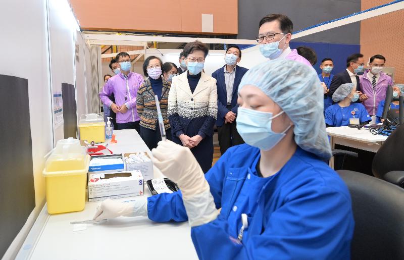 The Chief Executive, Mrs Carrie Lam, today (March 10) visited the Community Vaccination Centre at Sun Yat Sen Memorial Park Sports Centre. Photo shows Mrs Lam (third left) learning more about the procedure of diluting the vaccines. Looking on are the Secretary for Food and Health, Professor Sophia Chan (second left) and the Chairman of the Hospital Authority, Mr Henry Fan (fourth left).