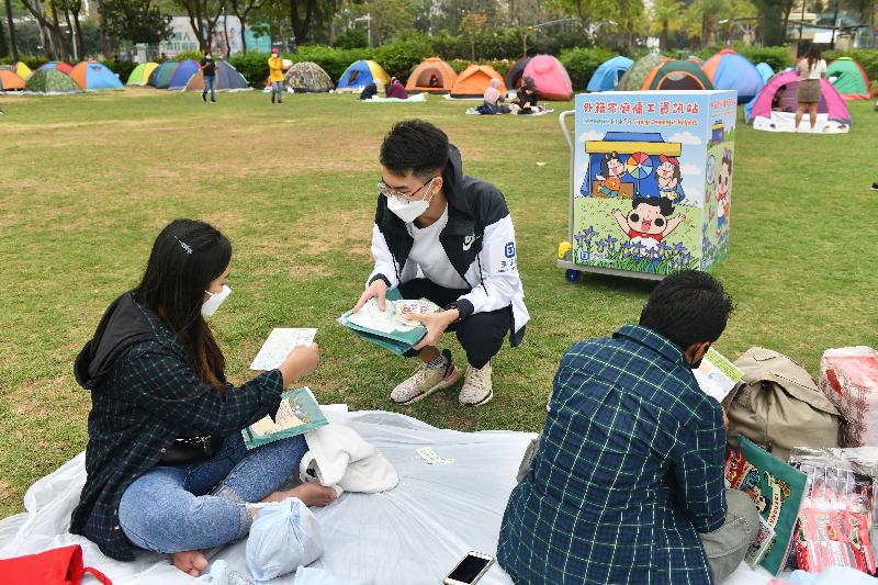 The Labour Department (LD) set up mobile specimen collection stations at popular gathering places of foreign domestic helpers (FDHs) to provide a free COVID-19 testing service for FDHs today (March 14). Photo shows promotional leaflets being distributed by the LD to FDHs at Victoria Park in Causeway Bay.