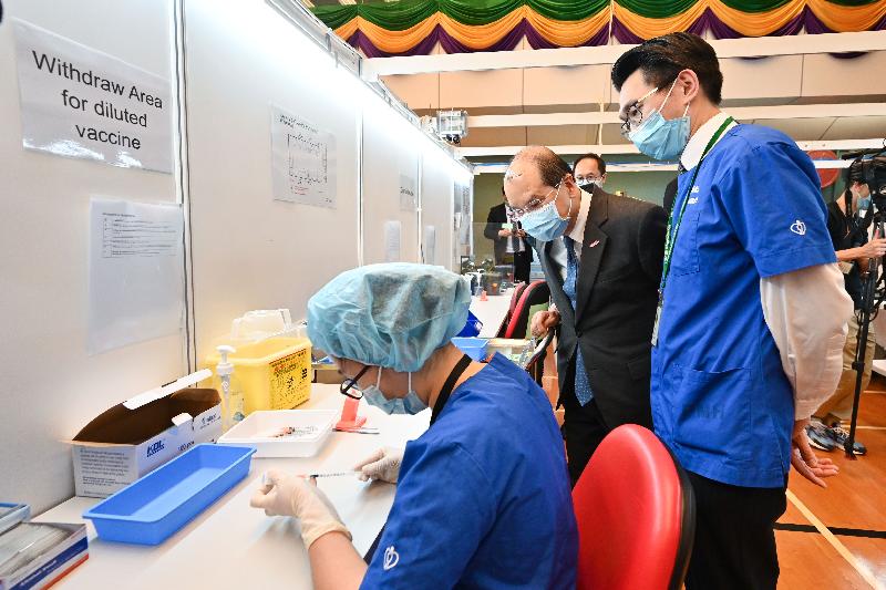 The Chief Secretary for Administration, Mr Matthew Cheung Kin-chung, visited the Community Vaccination Centre at Lai Chi Kok Park Sports Centre in Sham Shui Po today (March 16). Photo shows Mr Cheung (centre) learning more about the procedure of diluting a vaccine.