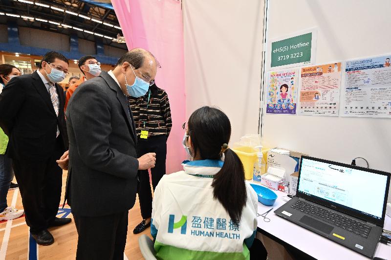 The Chief Secretary for Administration, Mr Matthew Cheung Kin-chung, visited the Community Vaccination Centre at Yau Oi Sports Centre in Tuen Mun today (March 16). Photo shows Mr Cheung (second right) chatting with a staff member to learn about her work.