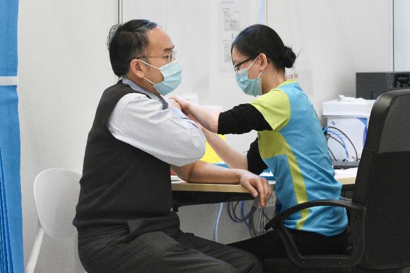 The Chief Executive, Mrs Carrie Lam, together with a number of Secretaries of Departments and Directors of Bureaux, received the second COVID-19 vaccination dose at the Conference Hall, Central Government Offices, Tamar, this morning (March 22). Photo shows the Secretary for Financial Services and the Treasury, Mr Christopher Hui (left), receiving the vaccine.