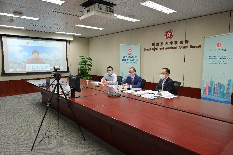 The Secretary for Constitutional and Mainland Affairs, Mr Erick Tsang Kwok-wai, today (April 2) chaired five briefing sessions by video conferencing to introduce the background, concepts and main contents of improving the electoral system of the HKSAR for representatives of associations formed by Hong Kong residents in the Mainland and Hong Kong residents living in the Mainland via Mainland offices of the HKSAR Government in Beijing, Guangdong, Shanghai, Chengdu and Wuhan. Photo shows Mr Tsang (second right) explaining the improvements to the HKSAR's electoral system and relevant arrangements to the Director of the Hong Kong Economic and Trade Office in Shanghai, Mrs Laura Aron (on the screen) and Hong Kong residents living in the Mainland.