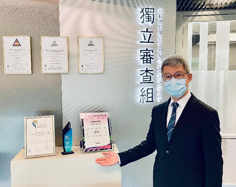 Mr Martin Tsoi, Head of the Independent Checking Unit (ICU), showing numerous awards that the ICU won for its application of advanced technologies to building control work.