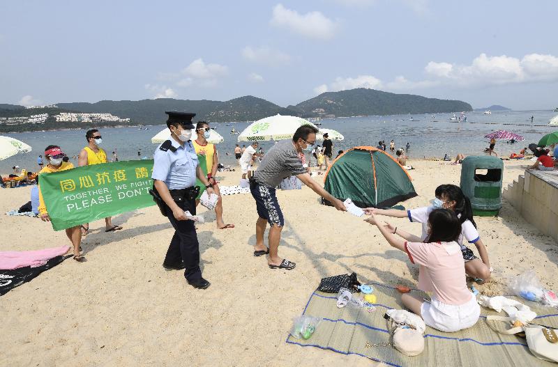 The Leisure and Cultural Services Department (LCSD) stepped up patrols at venues under its management during the Easter holiday to ensure users were complying with regulations on the limit of the number of people in group gatherings and the mask-wearing requirement. Photo shows LCSD staff conducting an inspection at Stanley Main Beach on April 2.