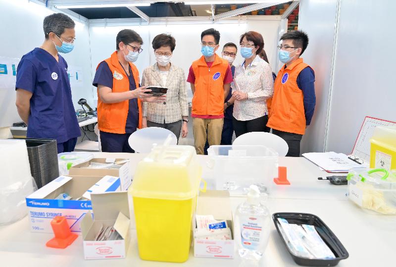 The Chief Executive, Mrs Carrie Lam, today (April 6) visited the Community Vaccination Centre (CVC) at Queen Elizabeth Stadium to inspect its operation and give encouragement to staff members. Picture shows Mrs Lam (third left)receiving a briefing by the personnel of the medical organisation running the CVC on the operation.