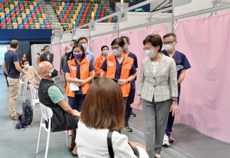 The Chief Executive, Mrs Carrie Lam, today (April 6) visited the Community Vaccination Centre (CVC) at Queen Elizabeth Stadium to inspect its operation and give encouragement to staff members. Photo shows Mrs Lam (second right) chatting with a member of the public who receives vaccine at the centre.