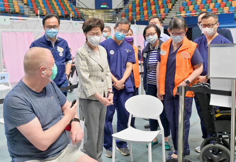 The Chief Executive, Mrs Carrie Lam, today (April 6) visited the Community Vaccination Centre (CVC) at Queen Elizabeth Stadium to inspect its operation and give encouragement to staff members. Photo shows Mrs Lam (third left) chatting with a member of the public who receives vaccine at the centre.