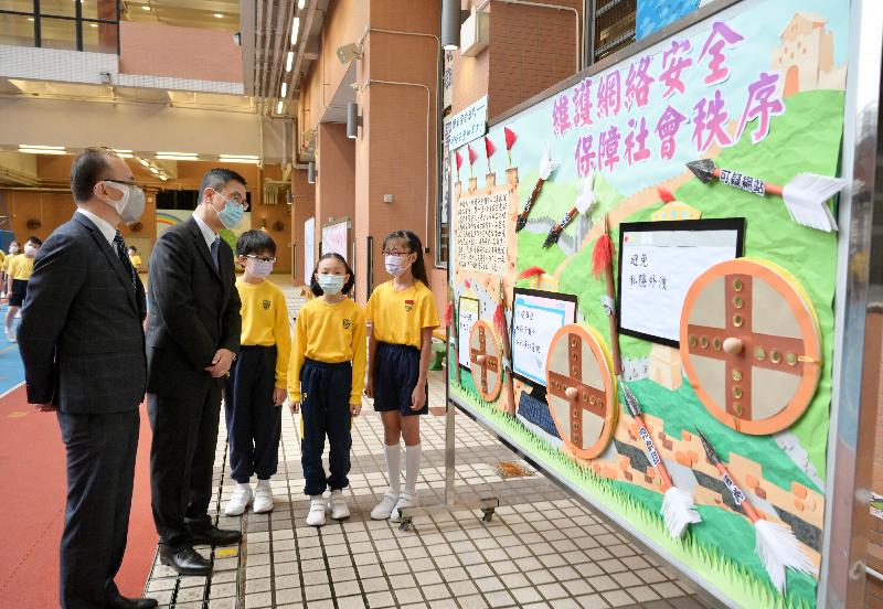 The Education Bureau together with schools in Hong Kong organised a variety of student activities today (April 15) in support of the National Security Education Day to promote national security education. Photo shows the Secretary for Education, Mr Kevin Yeung (second left), viewing one of the students' entries for the "School Bulletin Board Design Competition on National Security" during his visit to SKH St James' Primary School.