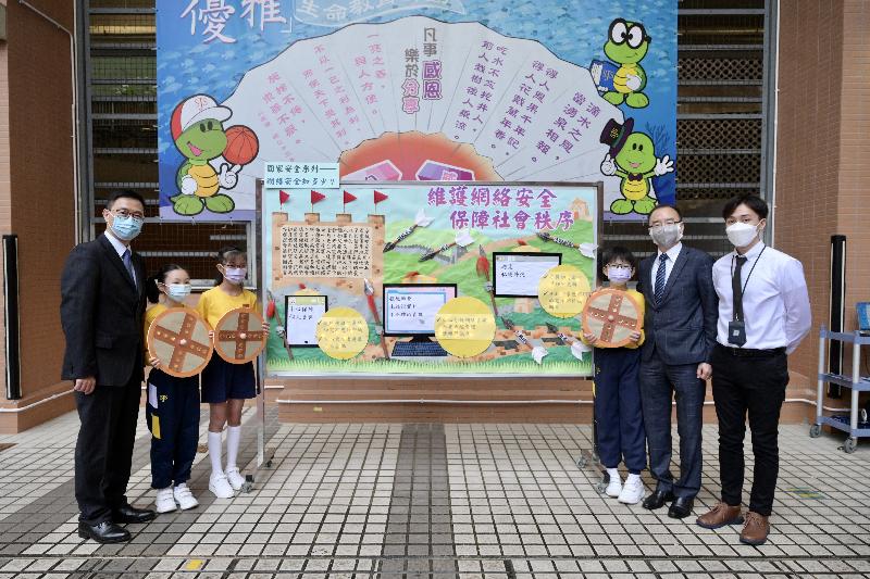 The Education Bureau together with schools in Hong Kong organised a variety of student activities today (April 15) in support of the National Security Education Day to promote national security education. Photo shows the Secretary for Education, Mr Kevin Yeung (first left), with one of SKH St James' Primary School's entries for the "School Bulletin Board Design Competition on National Security". Mr Yeung is pictured with the SKH St James' Primary School Principal, Mr Cheung Yung-pong (second right), and students during his visit to the school.