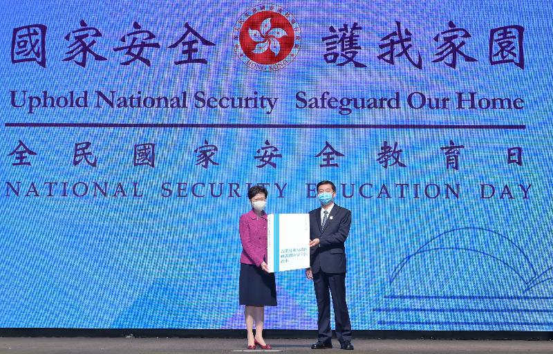 The Chief Executive, Mrs Carrie Lam, attended the National Security Education Day 2021 Opening Ceremony this morning (April 15). Photo shows the Director of the Liaison Office of the Central People's Government in the Hong Kong Special Administrative Region, Mr Luo Huining (right), presenting a book as a gift to Mrs Lam (left) at the ceremony.