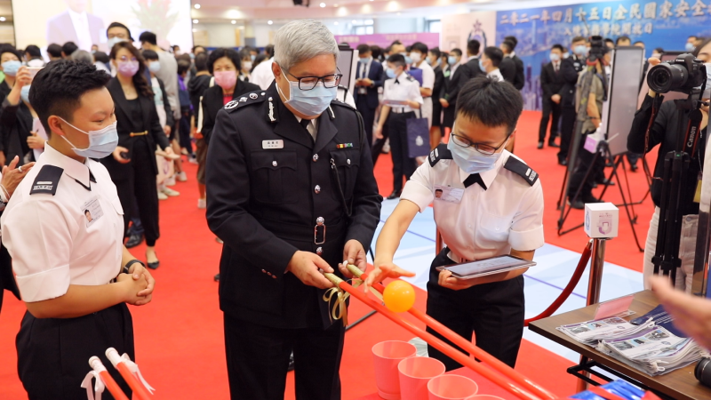 The Director of Immigration, Mr Au Ka-wang (centre), visits a game booth during the Immigration Department Institute of Training and Development Open Day for National Security Education Day today (April 15). 