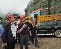 Photo showing Mr Tang being briefed on the re-construction progress of the Shuimo Secondary School in Wenchuan.