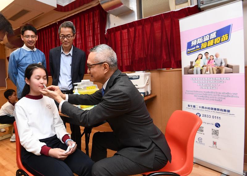 The Under Secretary for Food and Health, Dr Chui Tak-yi (front row, right), administers a nasal influenza vaccine for a student during his visit at St Eugene de Mazenod Oblate Primary School today (November 20). Also present are the Controller of the Centre for Health Protection of the Department of Health, Dr Wong Ka-hing (back row, right), and the Clinical Assistant Professor of the School of Public Health of the University of Hong Kong, Dr Tam Yat-hung (back row, left).