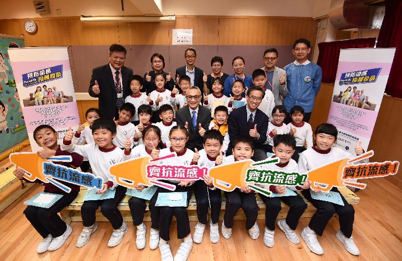 The Under Secretary for Food and Health, Dr Chui Tak-yi (second row, centre), and the Clinical Associate Professor and Division Head of the Division of Community Medicine and Public Health Practice of the University of Hong Kong's School of Public Health, Dr Dennis Ip (second row, third right), are pictured with (fourth row, from left) the Principal, Mr Yip Chi Shing; the Head of the Programme Management and Professional Development Branch of the Department of Health, Dr Liza To; the Controller of the Centre for Health Protection of the Department of Health, Dr Wong Ka-hing; the Vice-Principal, Ms Ngai Lai-wa; the Vice-Chairman of the Parent-Teacher Association, Ms Iris Ng; the Chairman of the Parent-Teacher Association, Mr Fred Chan; the Clinical Assistant Professor of the School of Public Health of the University of Hong Kong, Dr Tam Yat-hung; and pupils after observing students receiving seasonal influenza vaccination at St Eugene de Mazenod Oblate Primary School today (November 20).