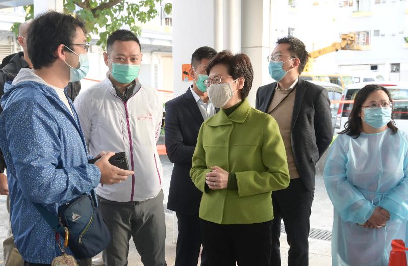 The Chief Executive, Mrs Carrie Lam (third right), visited Jat Min Chuen in Sha Tin this morning (December 24) to learn more about the first enforcement action on the COVID-19 compulsory testing notice conducted by the Sha Tin District Office and other departments. Photo shows Mrs Lam explaining to a resident herself that strict enforcement actions on compulsory testing could help achieve the purpose of community clearing.