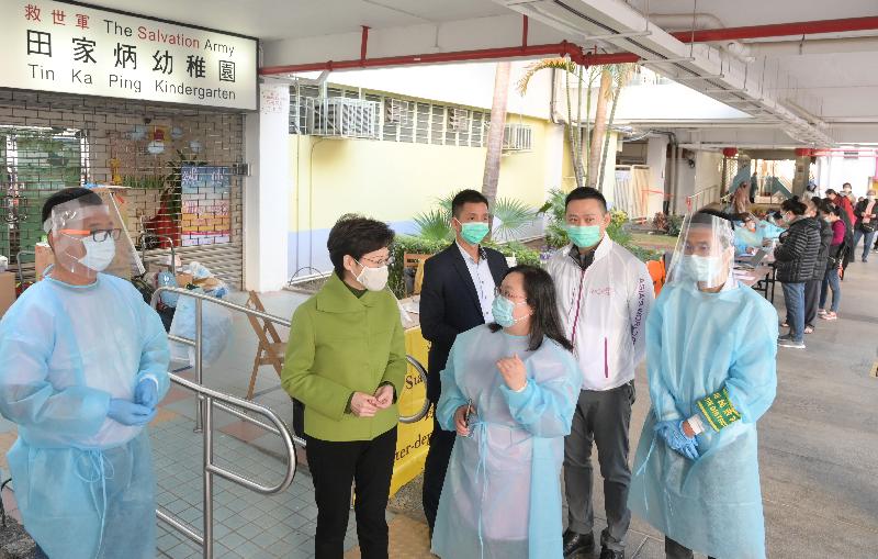 The Chief Executive, Mrs Carrie Lam (second left), visited Jat Min Chuen in Sha Tin this morning (December 24) to learn more about the first enforcement action on the COVID-19 compulsory testing notice conducted by the Sha Tin District Office and other departments.