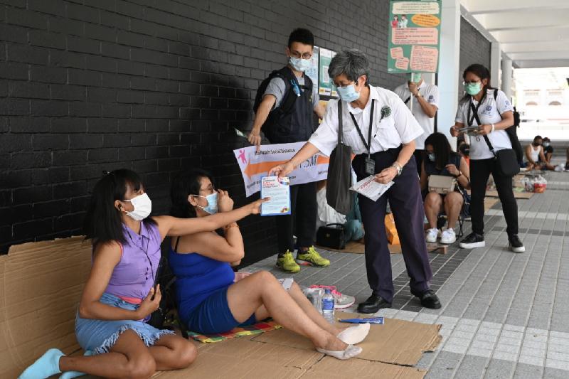 The Leisure and Cultural Services Department (LCSD) stepped up enforcement actions at venues under its management during the Labour Day holiday to deter people from breaking anti-epidemic regulations. Photo shows LCSD officers calling on the venue users to abide by the rules and giving them promotional leaflets about the regulations at Hong Kong City Hall today (May 1).