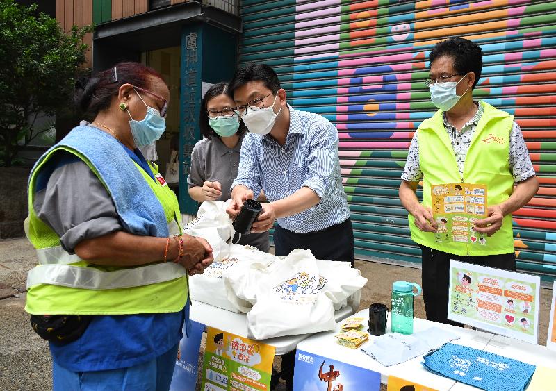 The Commissioner for Labour, Mr Chris Sun, visited cleaning workers working in Wan Chai today (May 5), reminding them as summer commences to take appropriate precautions to prevent heat stroke. Photo shows Mr Sun (second right) presenting a cleaning worker with a portable waist fan.