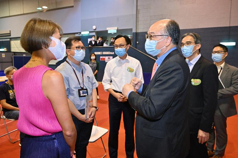 The Secretary for the Civil Service, Mr Patrick Nip, and the Secretary for Transport and Housing, Mr Frank Chan Fan, visited the Kowloon Bay Depot of the MTR Corporation Limited (MTRCL) today (June 17) to view the administering of a COVID-19 vaccine to staff members of the MTRCL as arranged by the Government's outreach vaccination service. Photo shows Mr Chan (third right) and Mr Nip (third left) chatting with MTRCL staff waiting to get vaccinated.