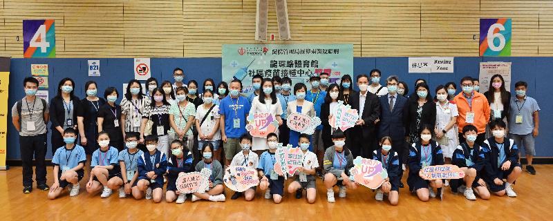 About 20 students, parents, teachers and school staff from Fanling Government Primary School received a COVID-19 vaccine at the Community Vaccination Centre at Lung Sum Avenue Sports Centre through group booking this afternoon (June 21). Photo shows them in a group photo after getting vaccinated. 