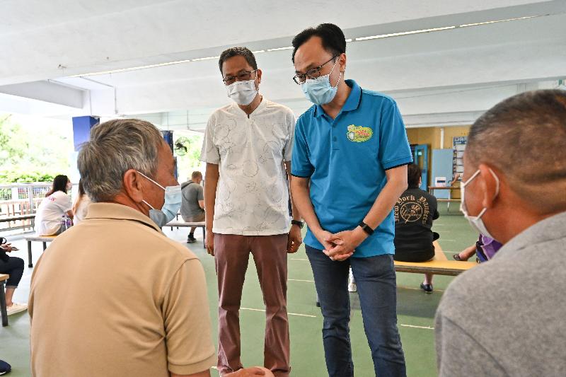 The Secretary for the Civil Service, Mr Patrick Nip, today (June 22) visited Sha Tau Kok to view the administering of the Sinovac vaccine to about 200 residents, including elderly people, as arranged by the Government's outreach vaccination service. Photo shows Mr Nip (second right), and the Chairman of the Sha Tau Kok District Rural Committee, New Territories, Mr Benjamin Lee (second left), chatting with residents  about to receive their Sinovac vaccination.