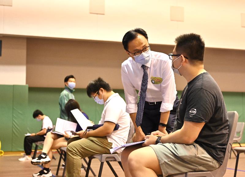The Secretary for the Civil Service, Mr Patrick Nip, visited the Hong Kong University of Science and Technology today (June 23) to view the administering of COVID-19 vaccines on the campus to students and teaching staff of the university and others as arranged by the Government's outreach vaccination service. Photo shows Mr Nip (second right) chatting with a student (first right) about to receive his COVID-19 vaccination.
 
