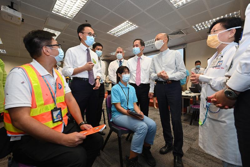 The Secretary for the Civil Service, Mr Patrick Nip, and the Secretary for the Environment, Mr Wong Kam-sing, today (June 25) visited the Castle Peak Power Station of CLP Power Hong Kong Limited (CLP) to view the administering of the Sinovac vaccine to staff members of the company as arranged by the Government's outreach vaccination service. Photo shows Mr Nip (second left) chatting with a representative from the medical team of the Community Vaccination Centre at Yuen Wo Road Sports Centre, which provided the outreach service today. Also present are Mr Wong (second right) and the Managing Director of CLP Power, Mr Chiang Tung-keung (third right)