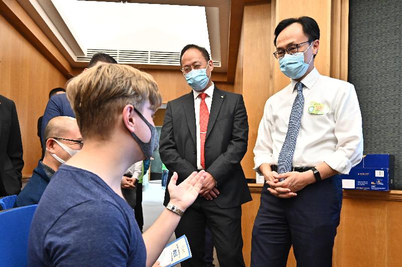 The Secretary for the Civil Service, Mr Patrick Nip, visited Hong Kong Baptist University (HKBU) today (June 30) to view the administering of a COVID-19 vaccine on the campus to students and teaching staff of the university as arranged by the Government's outreach vaccination service. Photo shows Mr Nip (first right) and the President and Vice-Chancellor of HKBU, Professor Alexander Wai (second right), chatting with a PhD student from Germany about to receive his COVID-19 vaccination.
