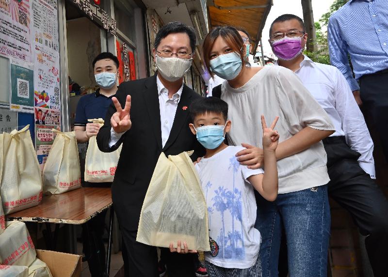 创新及科技局局长薛永恒（左）今日（七月一日）在观塘参与香港科创义工联盟「庆回归 贺百年」社区送暖活动，向基层家庭送赠福袋。