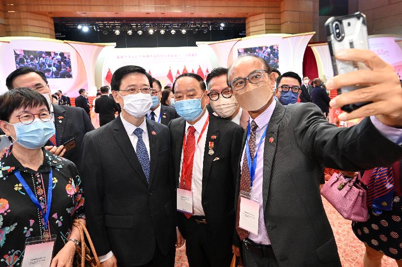 The Acting Chief Executive, Mr John Lee, together with Principal Officials and guests, attended the reception for the 24th anniversary of the establishment of the Hong Kong Special Administrative Region at the Hong Kong Convention and Exhibition Centre this morning (July 1). Photo shows Mr Lee (second left) taking photo with guests.