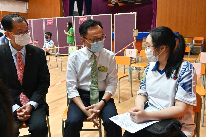 The Government's school outreach service for COVID-19 vaccination was launched today (July 2). The Secretary for the Civil Service, Mr Patrick Nip, visited Queen Elizabeth School Old Students' Association Secondary School to view the administering and arrangements for the outreach vaccination today. Photo shows Mr Nip (centre) chatting with a student (right) who had received her vaccination. Also present was the Chairman of the Queen Elizabeth School Old Students' Association Education Promotion Organization, Mr Henry Tong (left).
