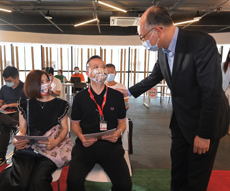 The Secretary for Transport and Housing, Mr Frank Chan Fan, today (July 5) visited the staff of the Kowloon Motor Bus Company (1933) Limited (KMB) and their family members who received COVID-19 vaccination at KMB's Kowloon Bay Depot. Photo shows Mr Chan (first right) chatting with a member of KMB's staff and his family member waiting to get vaccinated.