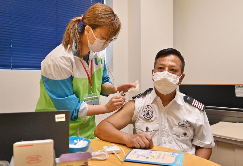The Secretary for the Civil Service, Mr Patrick Nip, visited Hong Kong Disneyland today (July 5) to view the administering of a COVID-19 vaccine to staff members of the theme park as arranged by the Government's outreach vaccination service. Photo shows a security staff receiving his COVID-19 vaccination. 
