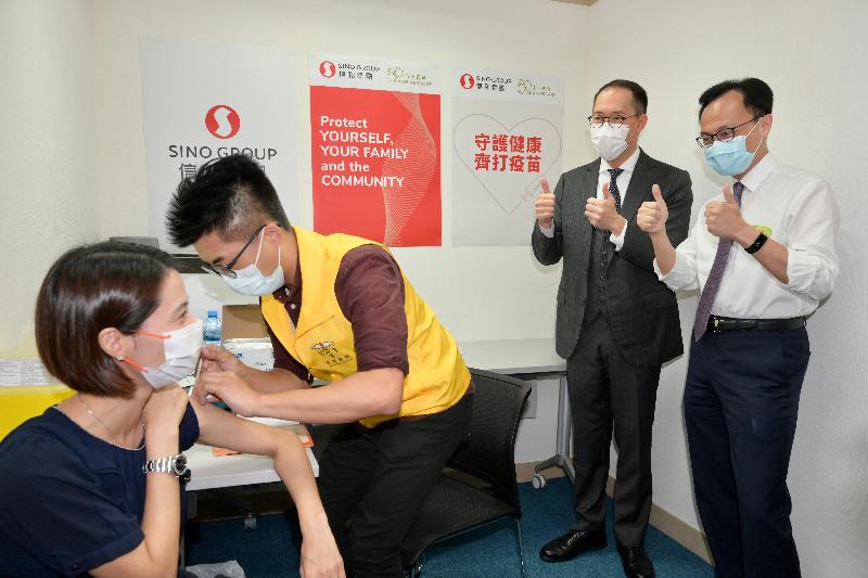 The Secretary for the Civil Service, Mr Patrick Nip (first right), visited Empire Centre in Tsim Sha Tsui today (July 7). During the visit, he and the Deputy Chairman of Sino Group, Mr Daryl Ng (second right), jointly viewed the administering of the Sinovac vaccine to staff members of the group, as arranged by the Government's outreach vaccination service. Photo shows a staff member receiving her COVID-19 vaccination.