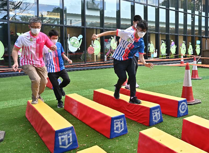 The Launching Ceremony of Junior Police Call (JPC) Summer Camp was held today (July 12). Photo shows the Commissioner of Police, Mr Siu Chak-yee (first left), taking part in an obstacle race with JPC members. 