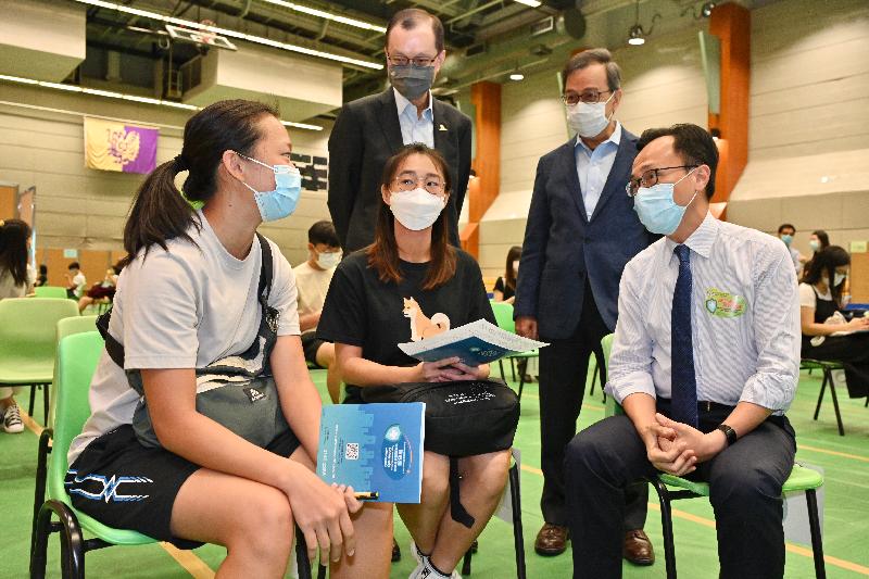 The Secretary for the Civil Service, Mr Patrick Nip, viewed the administering of a COVID-19 vaccine by the Government's outreach vaccination service at the Chinese University of Hong Kong (CUHK) today (July 14). Photo shows Mr Nip (front row, right) chatting with students about to receive their COVID-19 vaccination. Also present are the Acting Vice-Chancellor and Provost of CUHK, Professor Alan Chan (back row, right), and the Vice-President (Administration) of CUHK, Mr Eric Ng (back row, left).