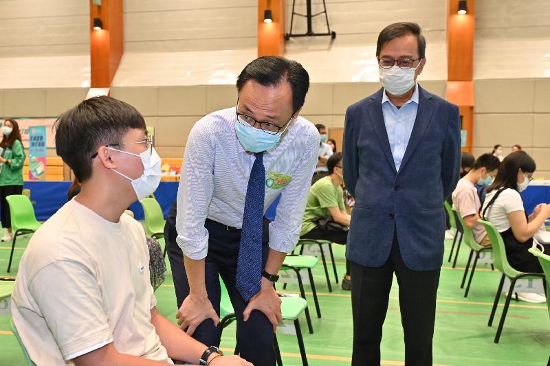 The Secretary for the Civil Service, Mr Patrick Nip, viewed the administering of a COVID-19 vaccine by the Government's outreach vaccination service at the Chinese University of Hong Kong (CUHK) today (July 14). Photo shows Mr Nip (centre) chatting with a student about to receive his COVID-19 vaccination. Also present is the Acting Vice-Chancellor and Provost of CUHK, Professor Alan Chan (right).