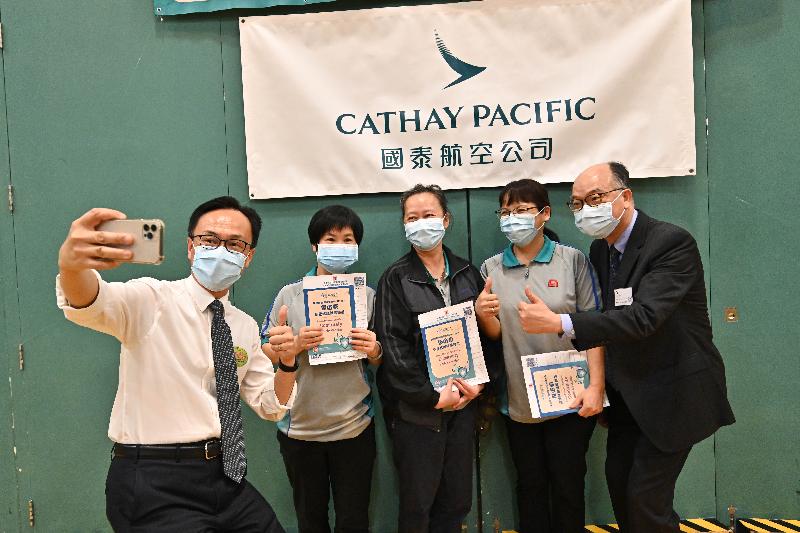The Secretary for the Civil Service, Mr Patrick Nip (first left), and the Secretary for Transport and Housing, Mr Frank Chan Fan (first right), visited Cathay Pacific City today (July 19) to view the administering of the BioNTech vaccine to staff members of Cathay Pacific, as arranged by the Government's outreach vaccination service. Photo shows them taking a selfie with staff members working in Cathay Pacific City who were vaccinated.