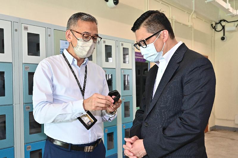 The Secretary for Security, Mr Tang Ping-keung, inspected the Tai Tam Gap Correctional Institution (TGCI) this morning (July 22) to learn more about the application of technology in the first "Smart Prison" of the Correctional Services Department. Photo shows Mr Tang (right) being briefed by the Commissioner of Correctional Services, Mr Woo Ying-ming, on the functions of the smart wristband provided for people being remanded in the TGCI.