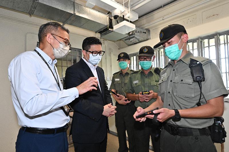 The Secretary for Security, Mr Tang Ping-keung, inspected the Tai Tam Gap Correctional Institution this morning (July 22) to learn more about the application of technology in the first "Smart Prison" of the Correctional Services Department. Photo shows Mr Tang (second left) being pleased to find that the Staff Handheld Device System is handy for the staff's execution of normal duties and effective in reducing their burdensome daily work procedures.