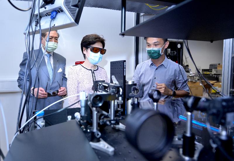 The Chief Executive, Mrs Carrie Lam, today (August 2) visited the University of Hong Kong (HKU). Photo shows Mrs Lam (centre), accompanied by the Council Chairman of HKU, Professor Arthur Li (left), touring the Photonic Systems Research Laboratory to learn about how the advanced biotechnology developed by the laboratory can help in clinical diagnosis including detection of cancer cells.